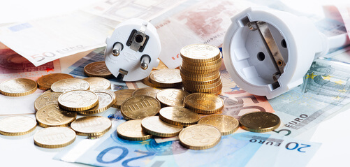 Pièces et billets en euros à côté d'un fil électrique