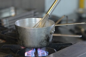 Casserole et fouet sur une gazinière